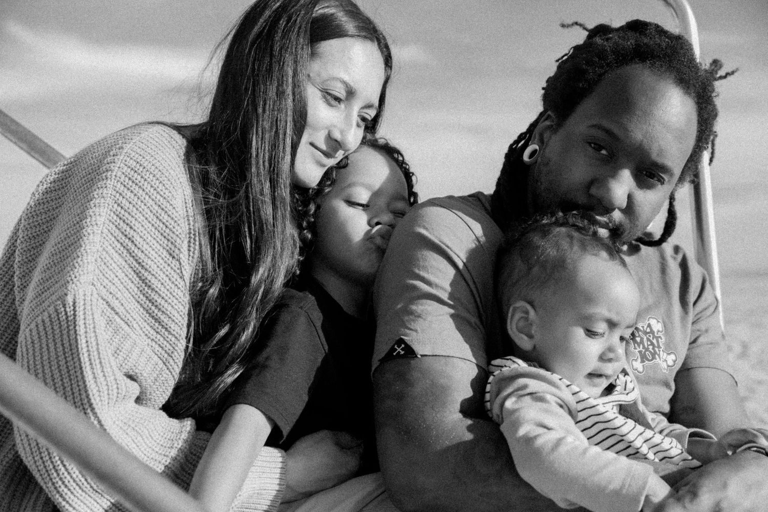 family portrait, black-and-white photography, outdoor bonding, diverse family, family values, lifestyle photography, parenting moments