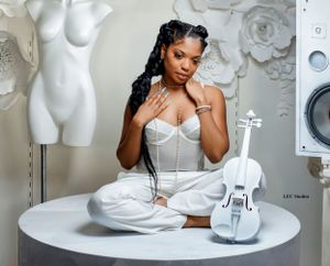 Studio portrait with white corset, violin and mannequin decorative elements.