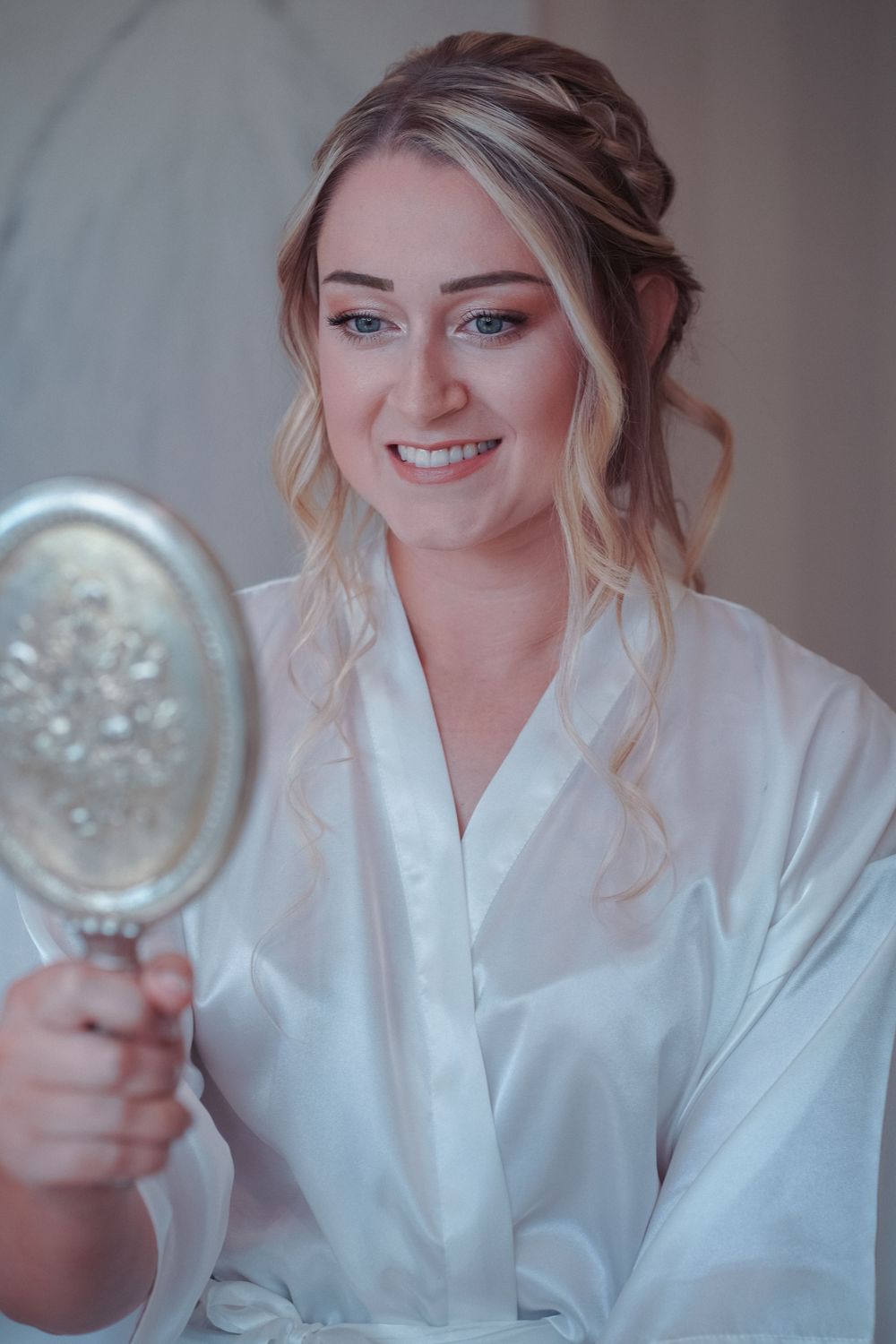 A series of photos showing someone in a white robe smiling and holding a decorative mirror in different poses.