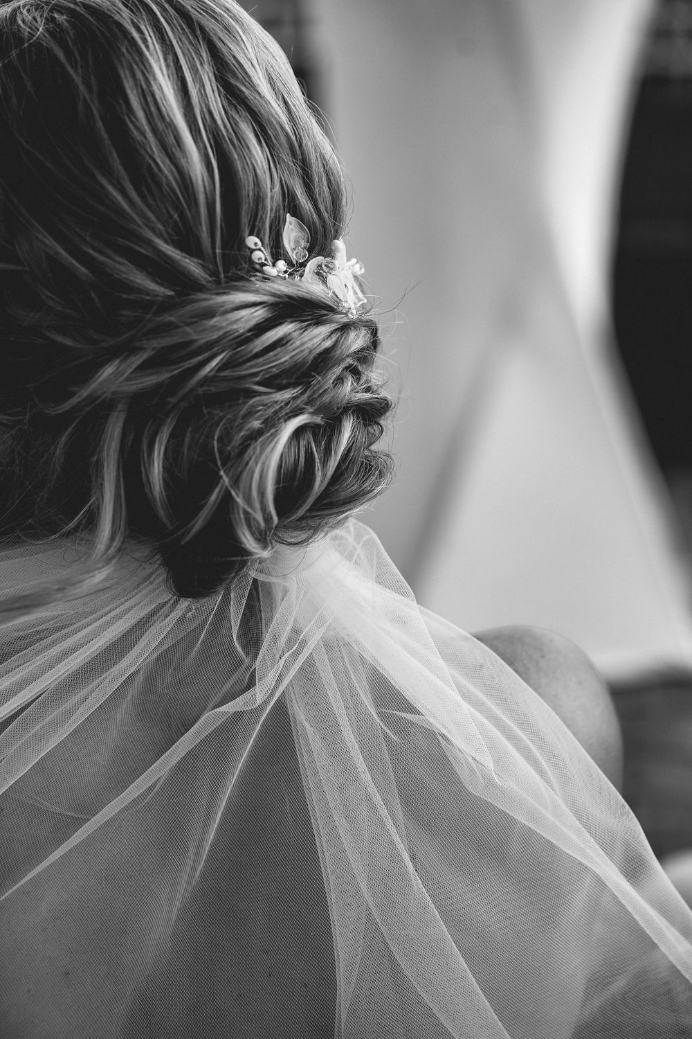 A black and white series of bridal hairstyle photos showing an elegant updo with veil from different angles.