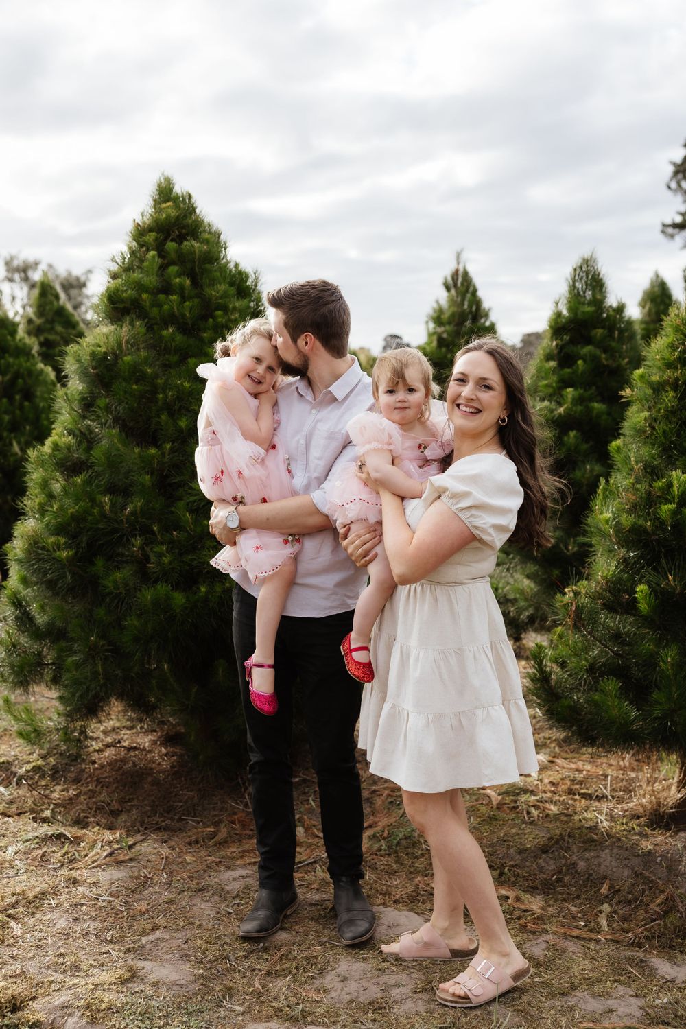 Candid family moment captured outdoors at a tree farm.