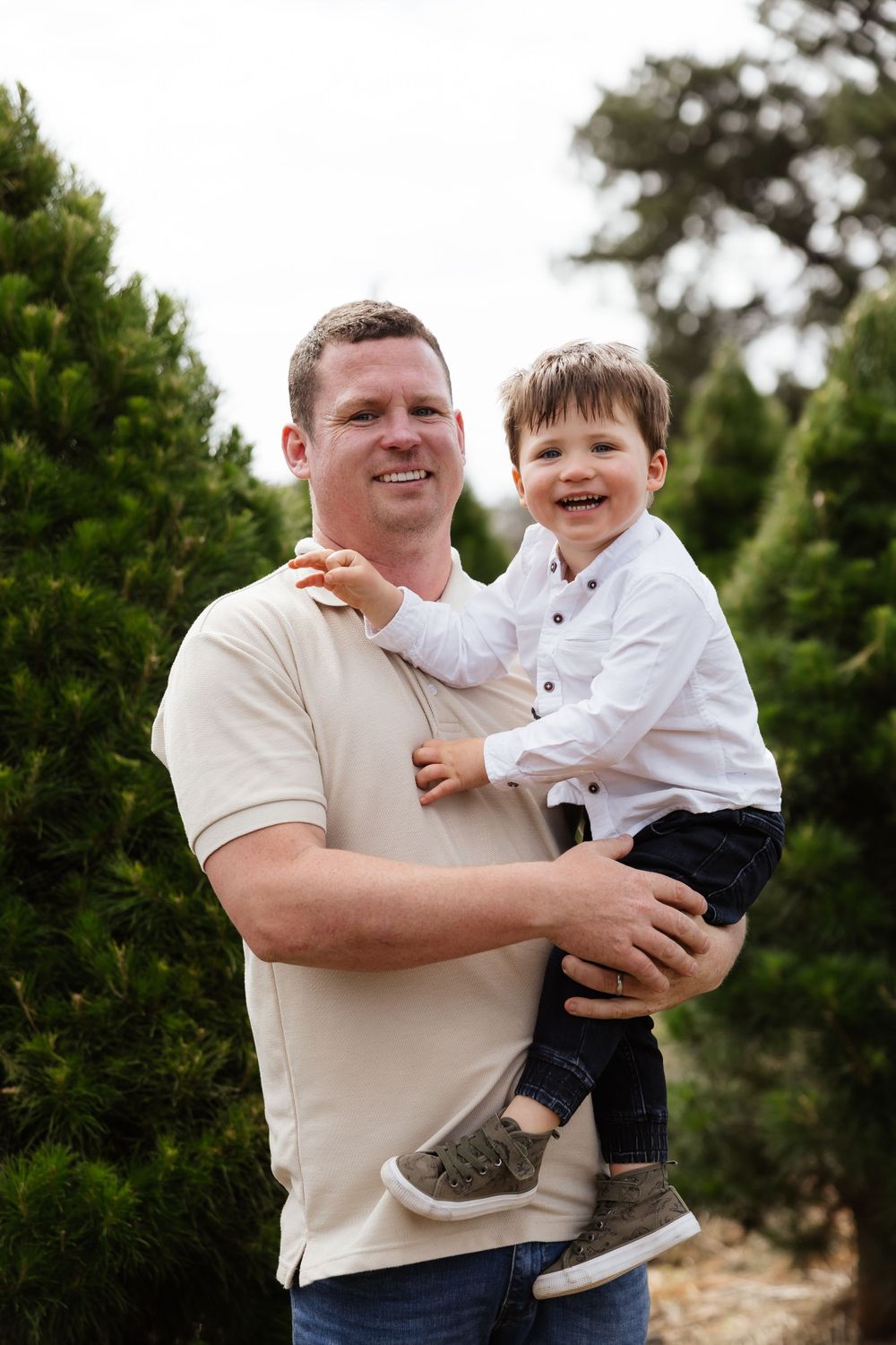 Playful father-child moment captured during outdoor family photoshoot.