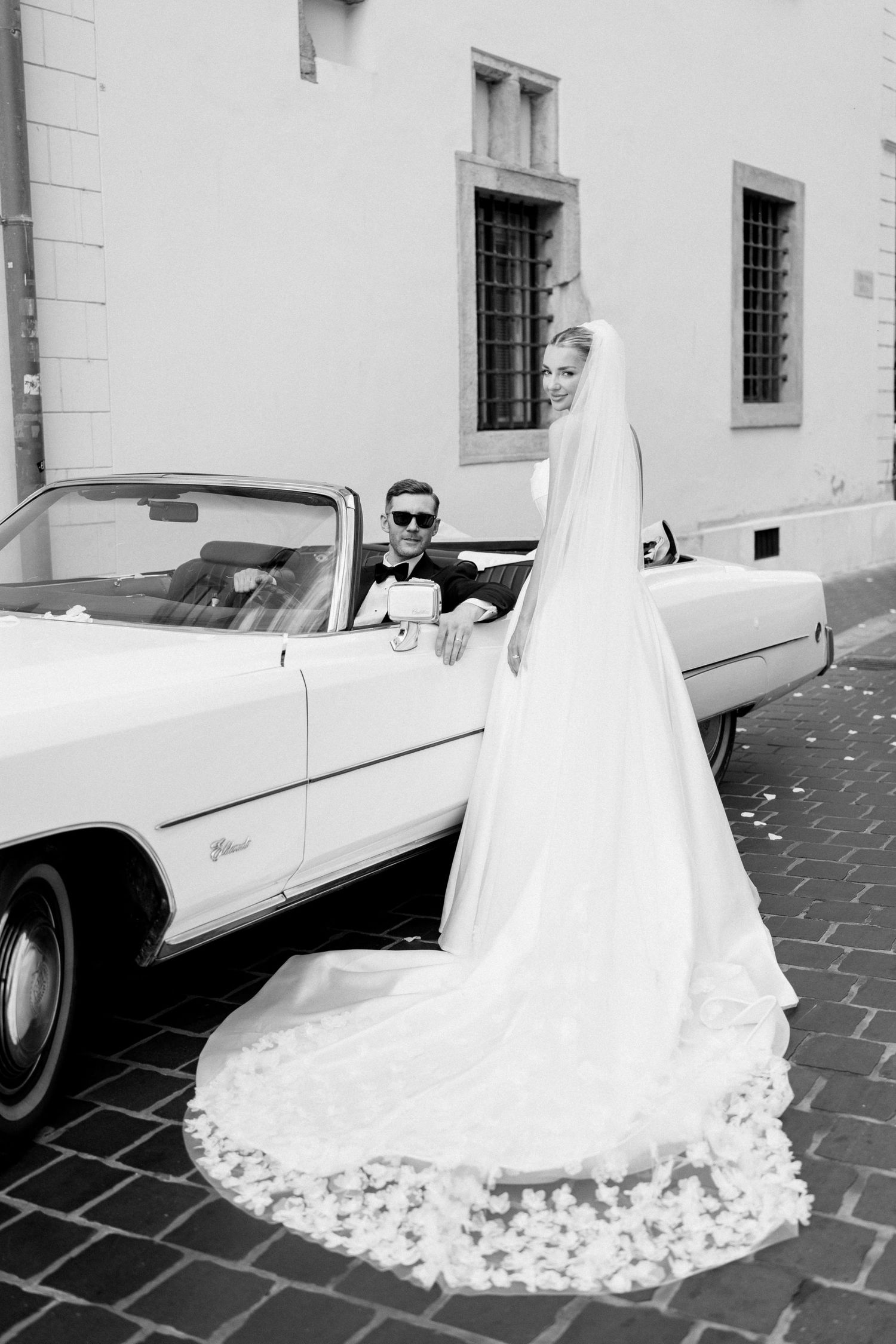 bride-and-groom-in-convertible-car-romantic-wedding-exit-in-budapest-destination-couple-photo.jpg