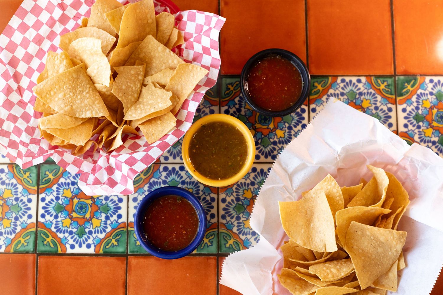 Chips and salsa meticulously arranged on a table to show off chip texture and salsa color creating appeal to eat at this restaurant