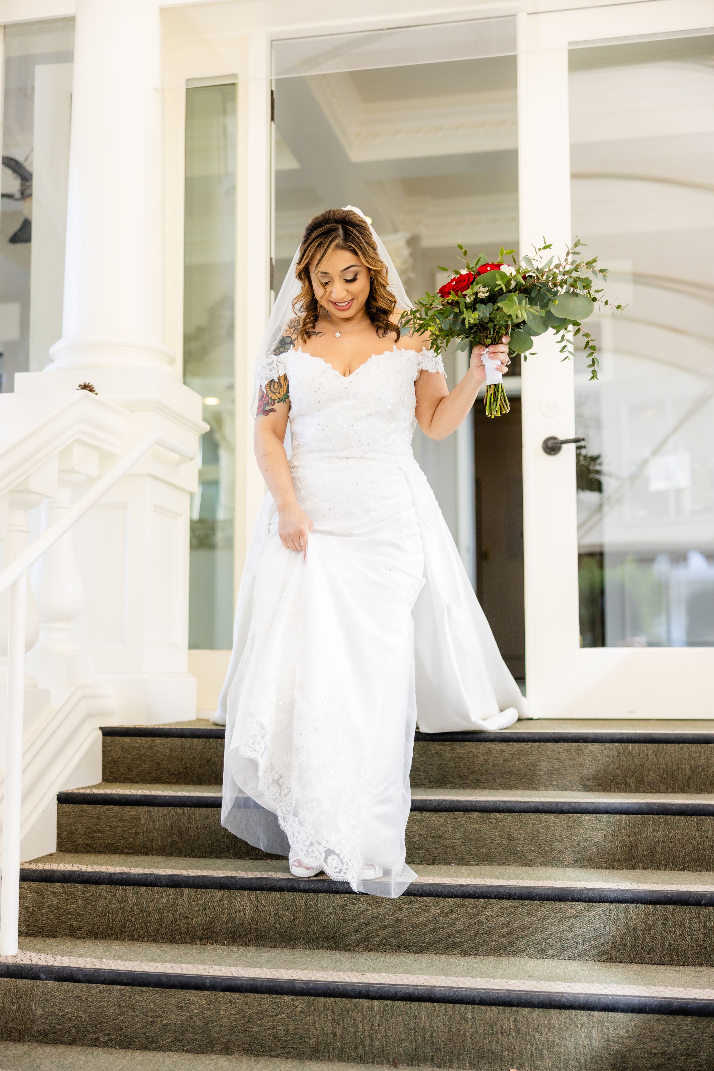 White wedding dress with lace details photographed on classic white building steps.