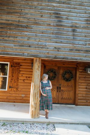 Sequential shots of walking along a rustic log cabin porch with wooden siding and decorative wreaths.
