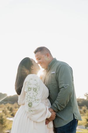 A couple embraces during a sunset photo session in a desert landscape setting.