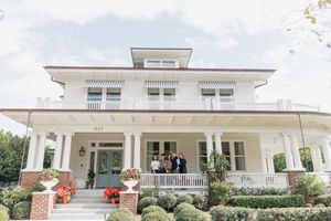 Elegant white colonial style house with wraparound porch and landscaped gardens viewed from multiple angles.