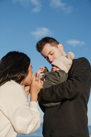A romantic sequence showing a couple in casual attire embracing against a blue sky background.