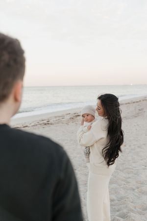 A couple shares a tender moment together on a serene beach during sunset.