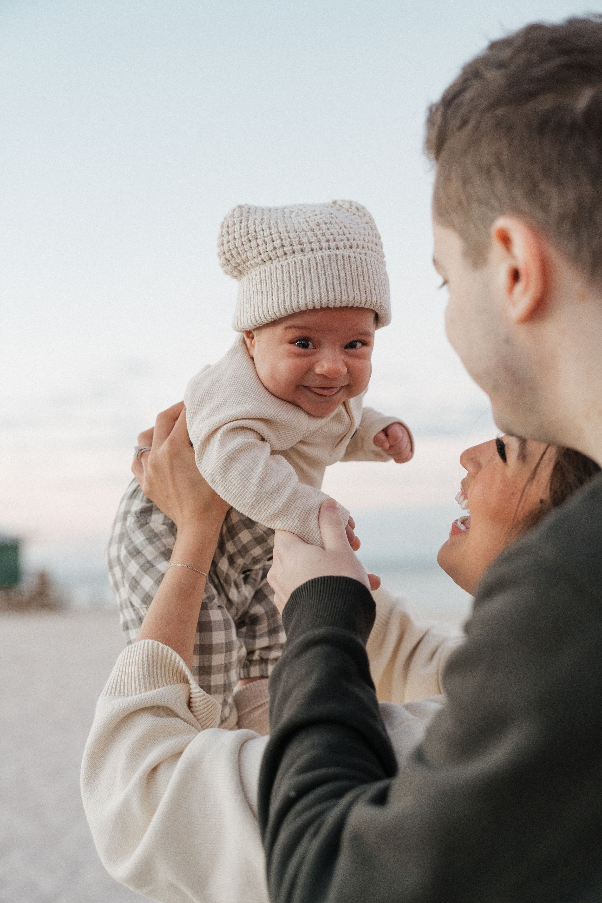 A playful sequence showing a couple in winter attire sharing a lighthearted moment against a bright background.