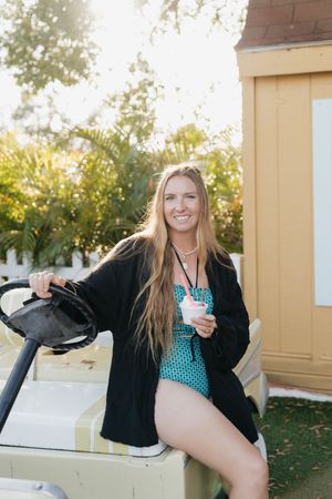 Woman in polka dot top and black jacket poses playfully outdoors in a series of casual shots.