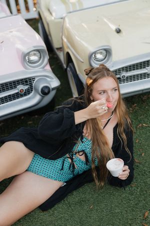 A series of five artistic photos showing someone posing on grass in front of a vintage white car.