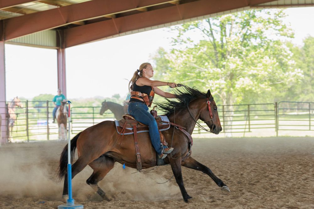 Pretty cowgirl demonstrating how she competes in Cowboy Mounted Shooting in the state of Missouri.