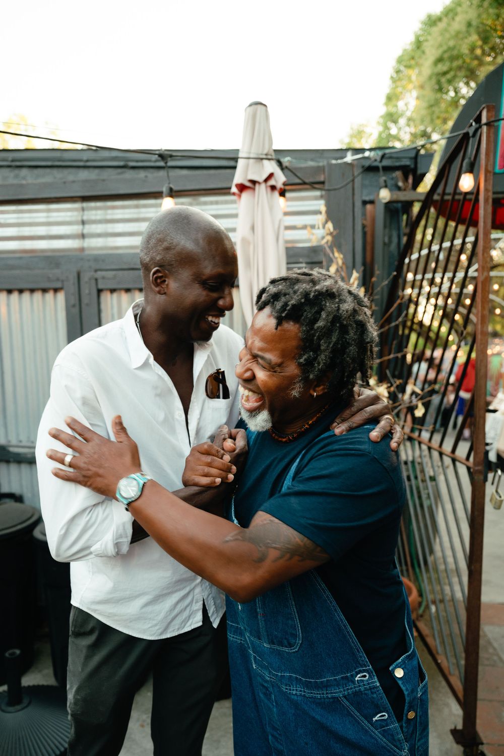 Two people playfully hugging and laughing together on a porch in a candid series of shots.