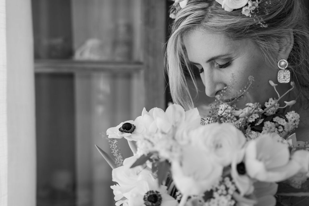 A black and white close-up of a bride holding a beautiful bouquet of white flowers with anemones.