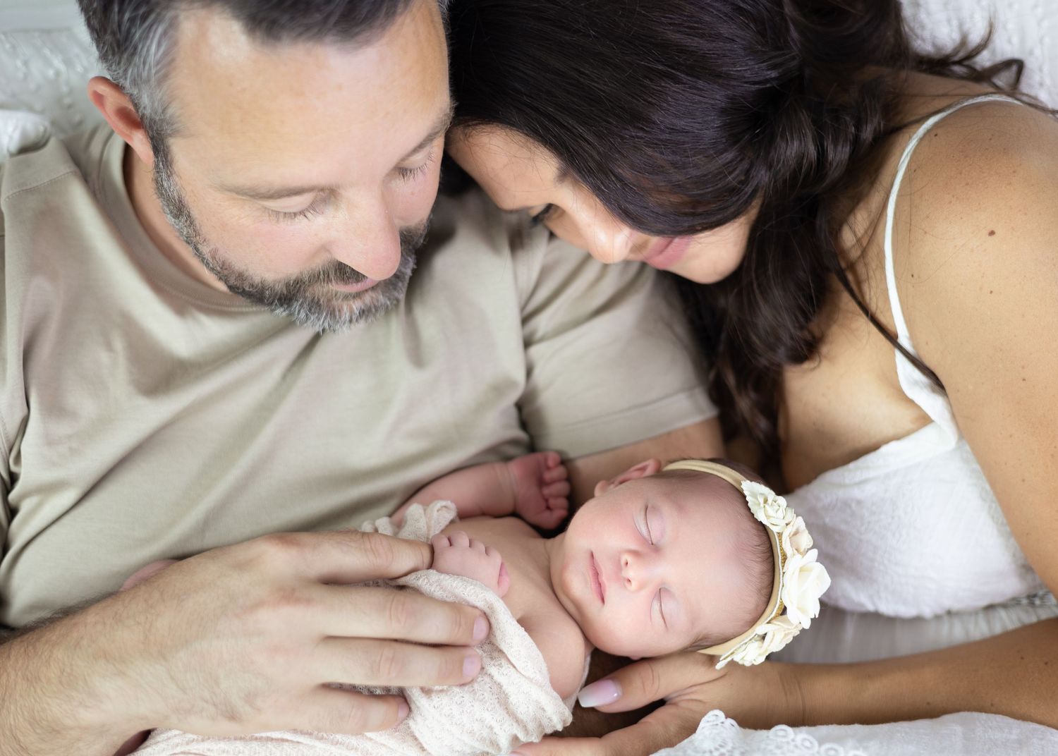 A series of tender moments between parent and sleeping baby showing gentle kisses and bonding.