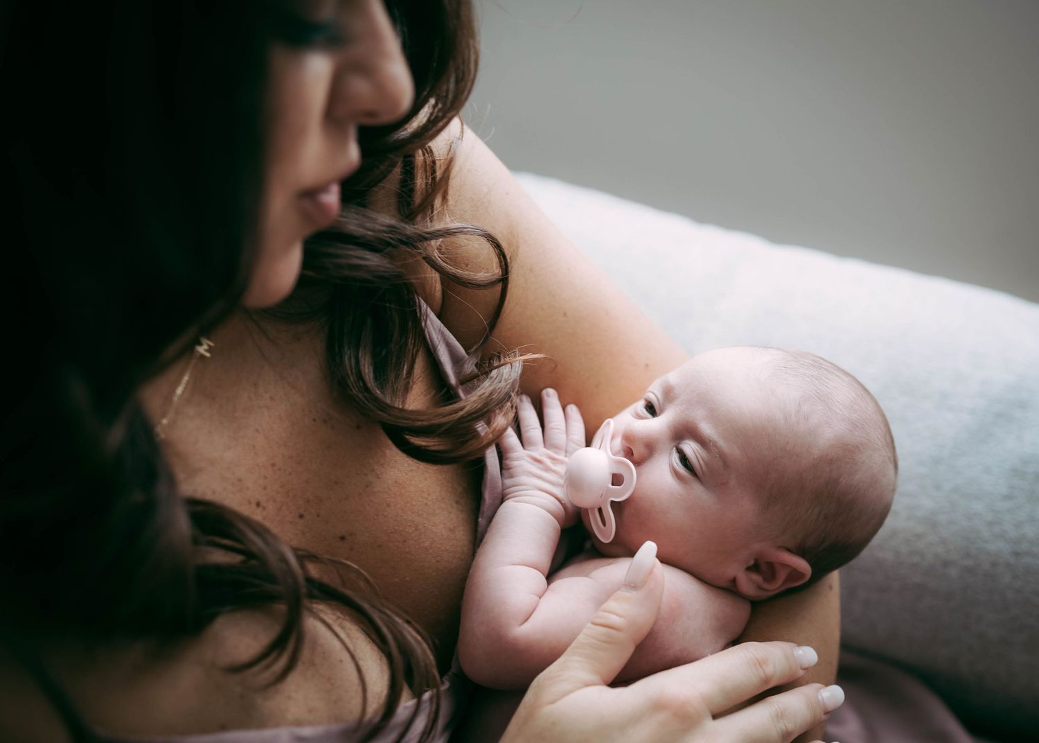 A tender moment between parent and newborn baby captured in a series of intimate black and white photographs.