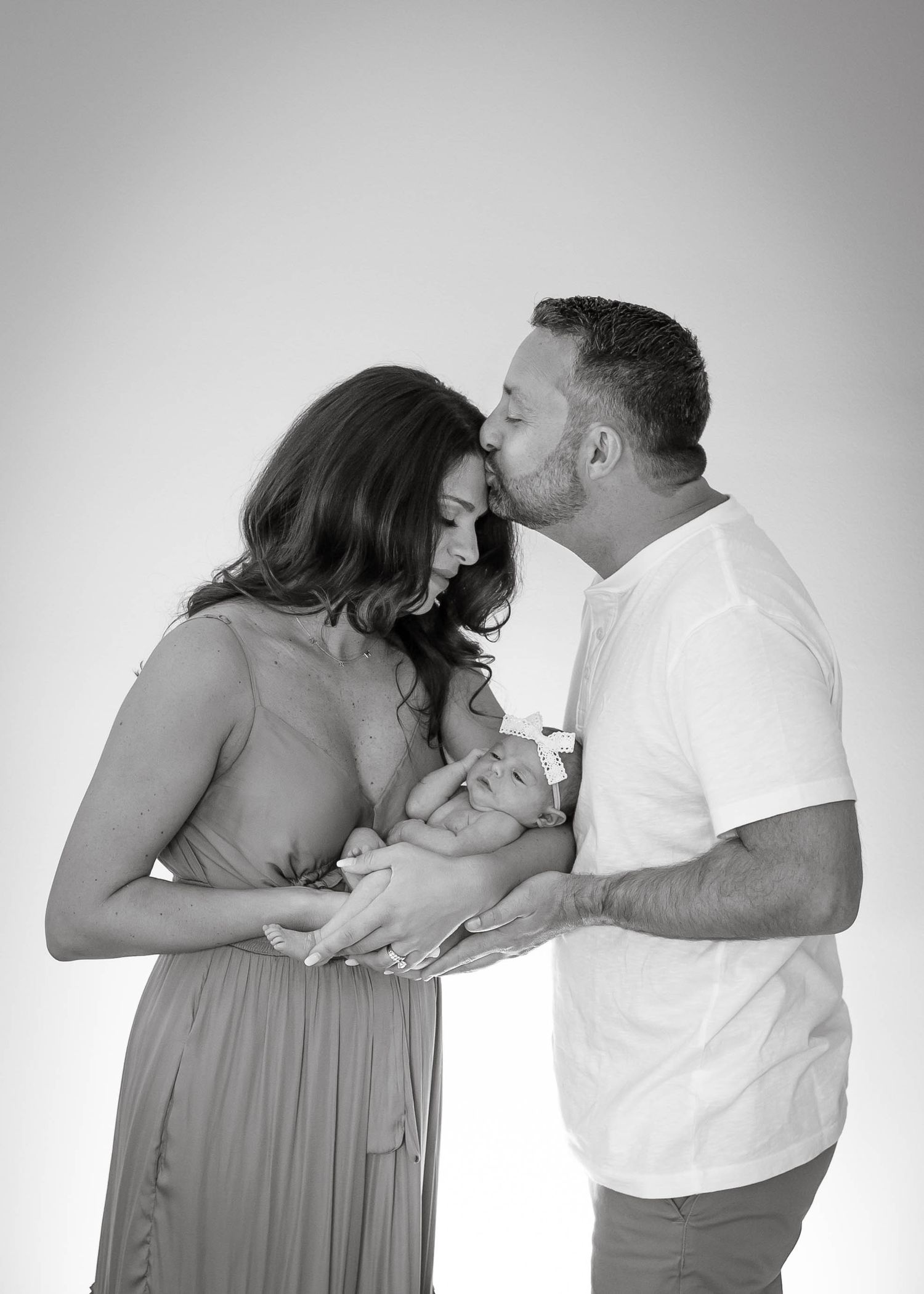 A couple in grey dress and white shirt share a tender moment in a black and white photo sequence.