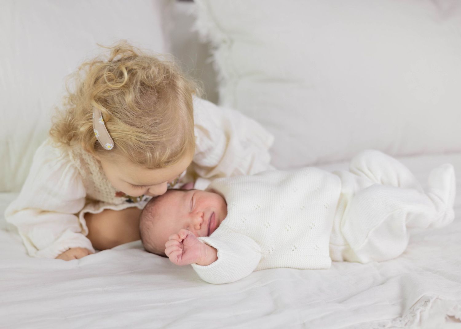 A series of peaceful sleeping baby photos in white showing gentle poses and soft lighting during an In-home Newborn session.