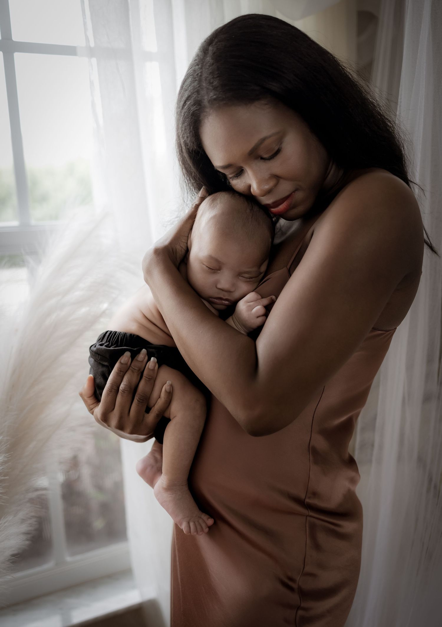 A tender series of black and white photographs showing intimate moments between mother and child by a window.