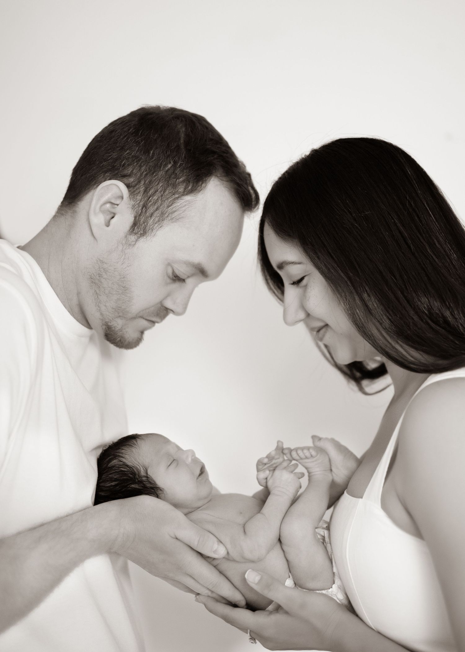 Black and white artistic series lifestyle photo showing tender family moments with a newborn baby.