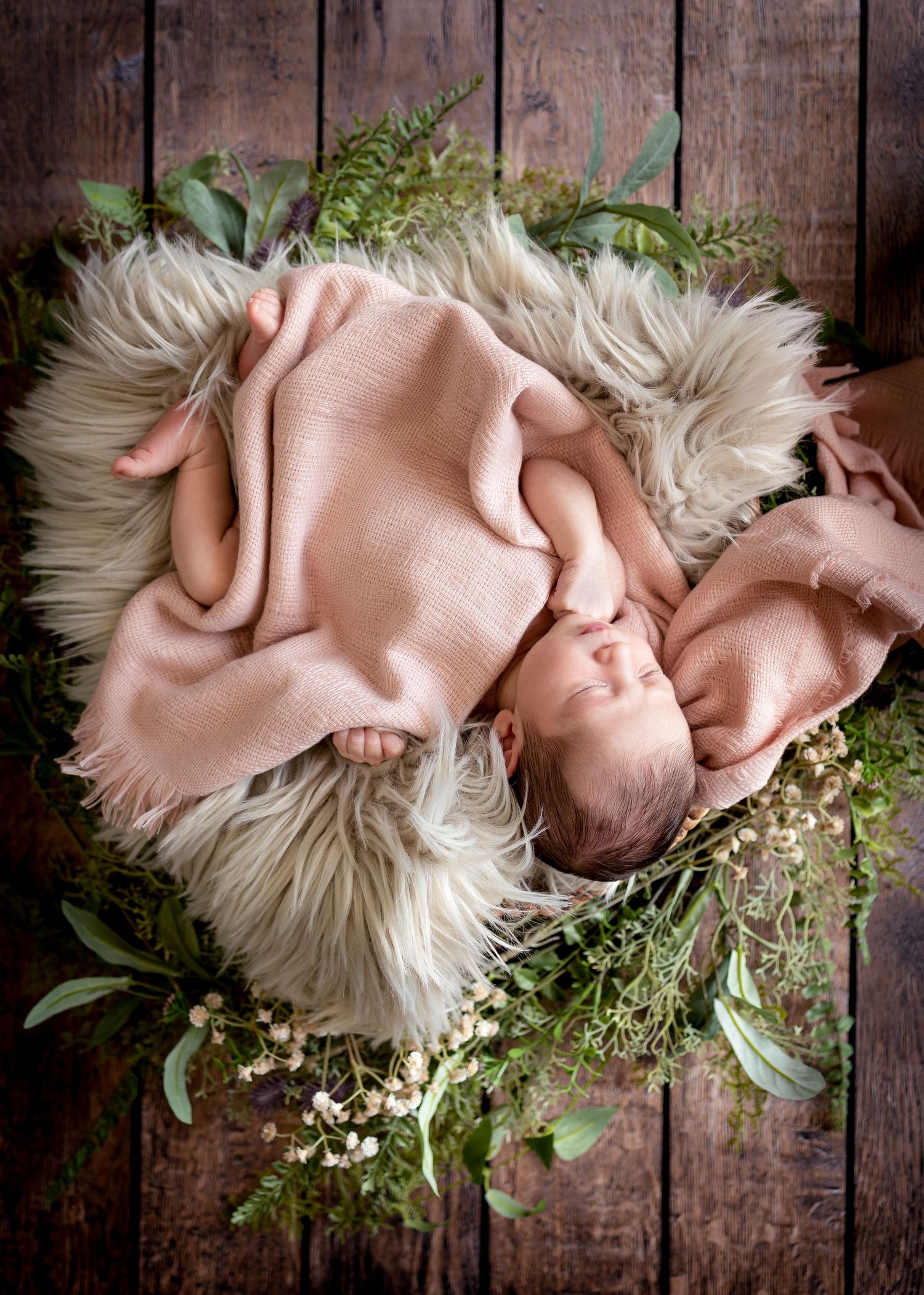 A delicate arrangement of white baby's breath flowers and eucalyptus leaves on a rustic wooden background.