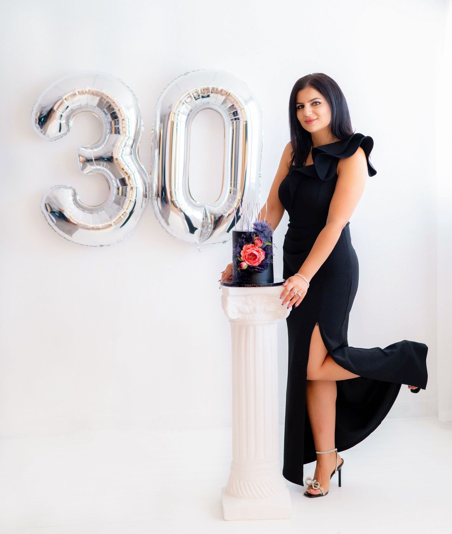Fashion photography with silver balloon numbers and black formal wear.