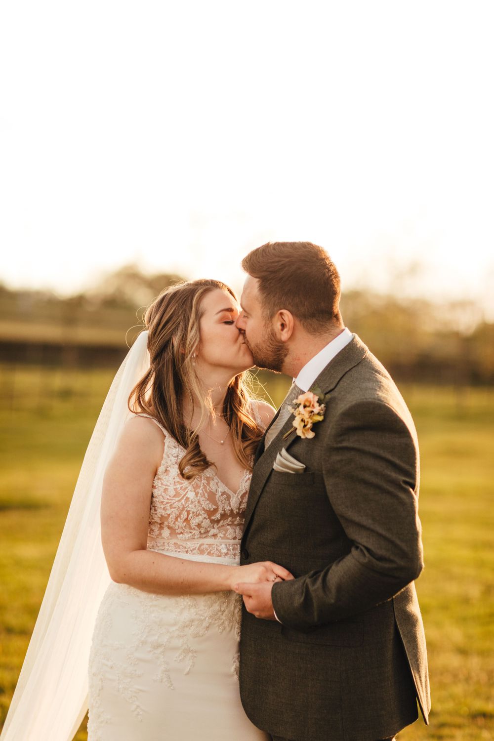 A romantic sunset wedding portrait with newlyweds sharing a tender moment in golden lighting.