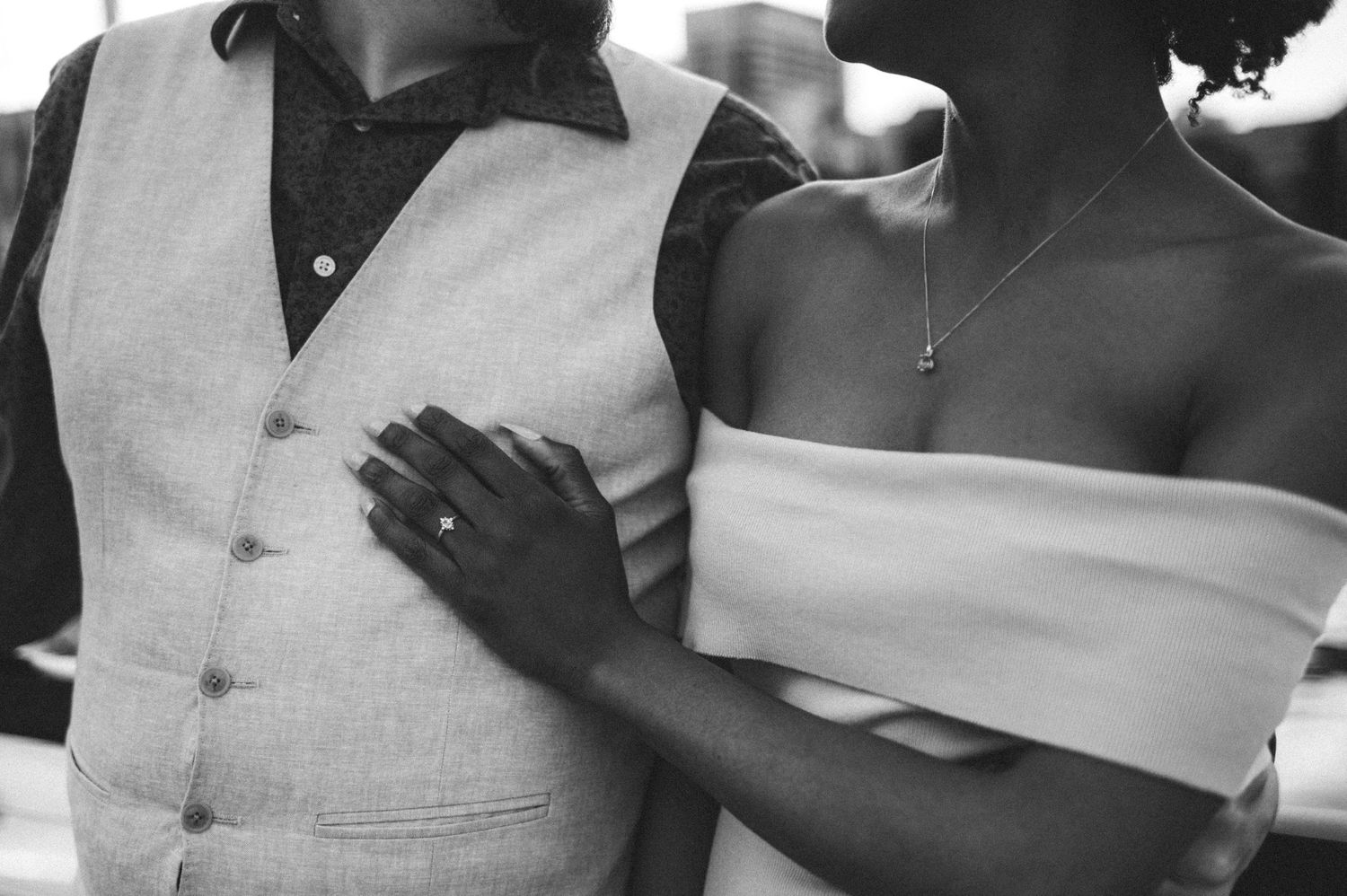 Close-up black and white detail of couple in wedding attire.