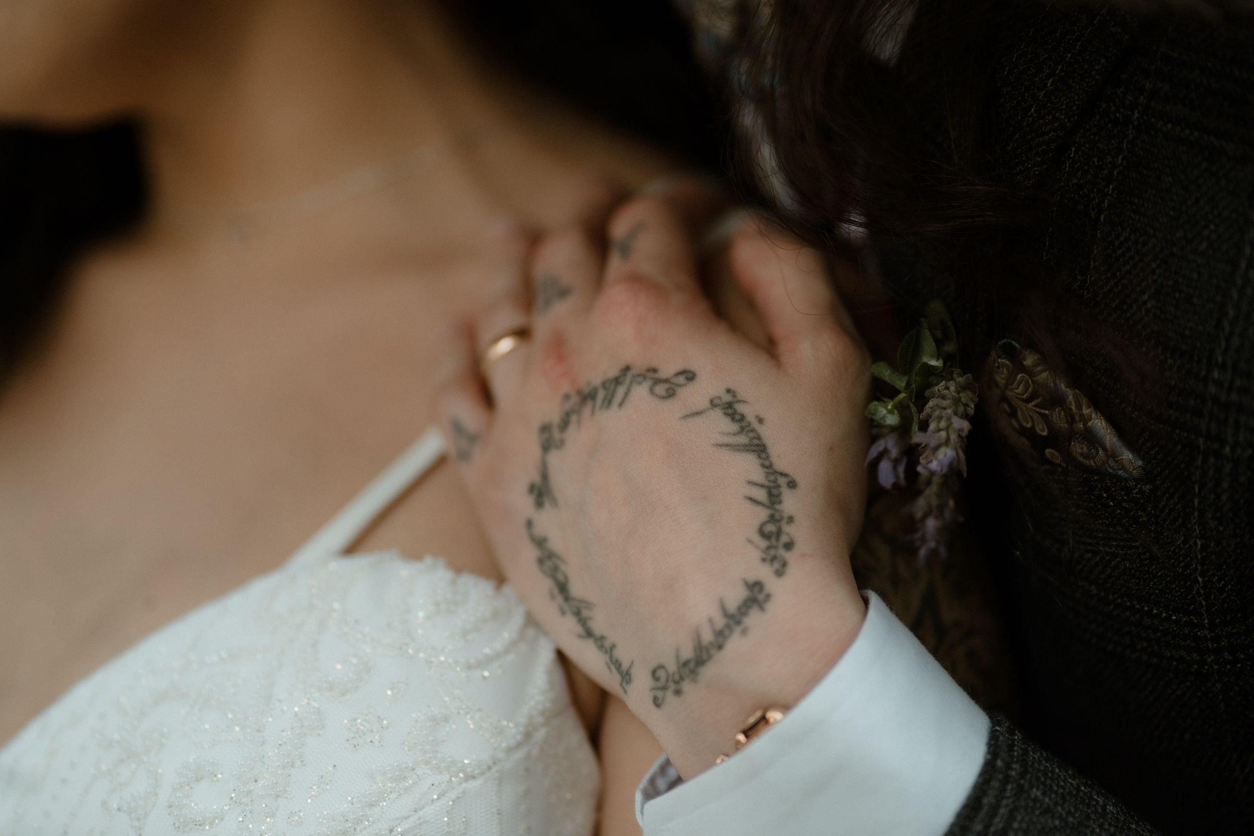 Delicate tattoo details and lace shown in close-up wedding photography.