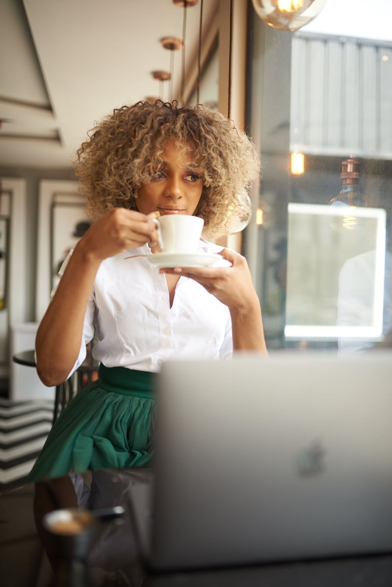 Casual lifestyle shots of someone working and drinking coffee at desk with laptop.