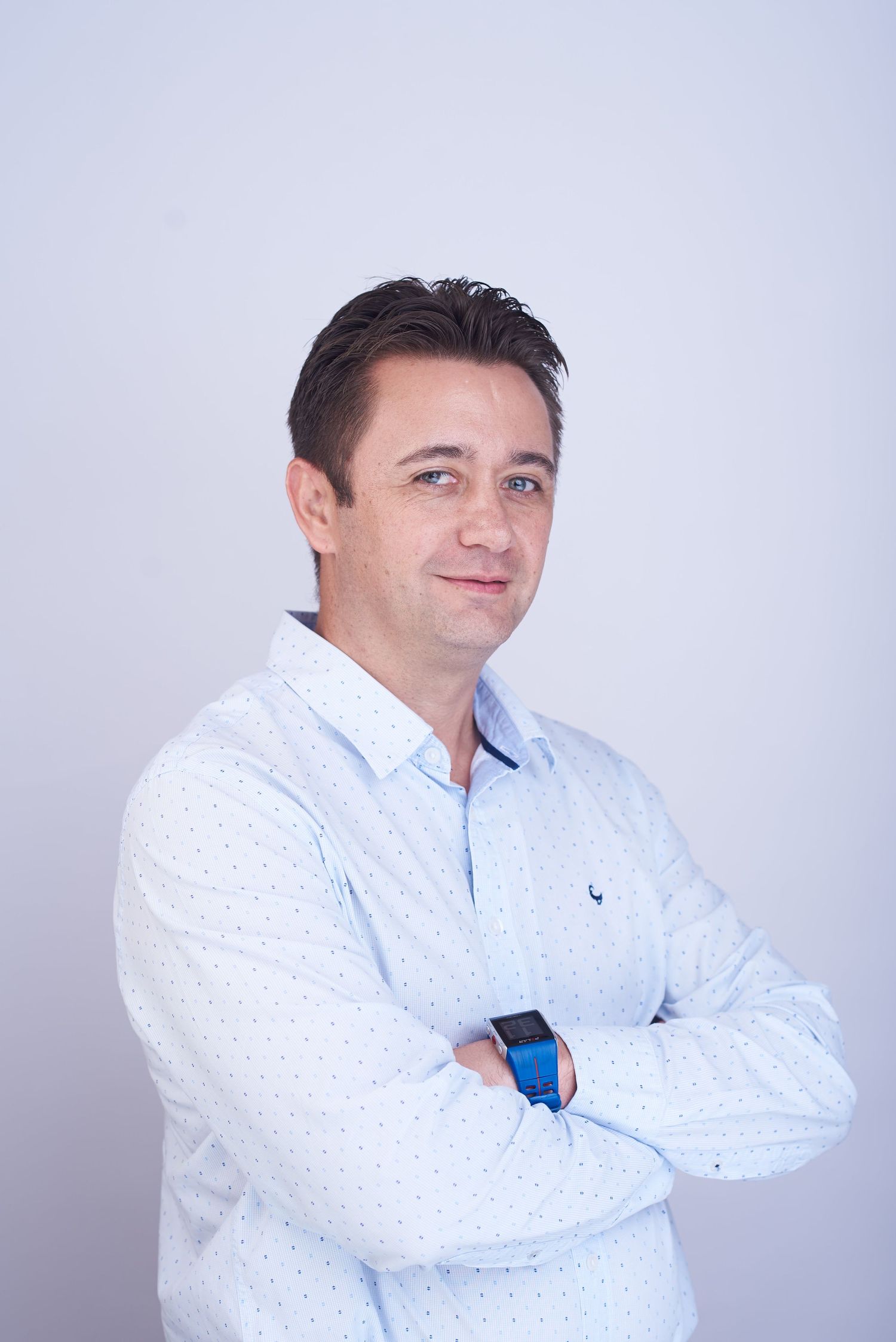 Professional headshots of person in light blue button-down shirt against white background.