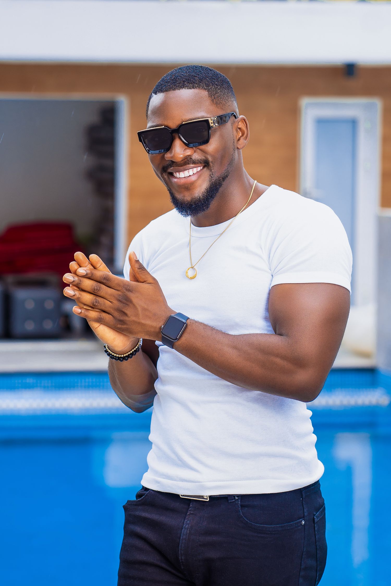 Casual portrait in white t-shirt and sunglasses by swimming pool.