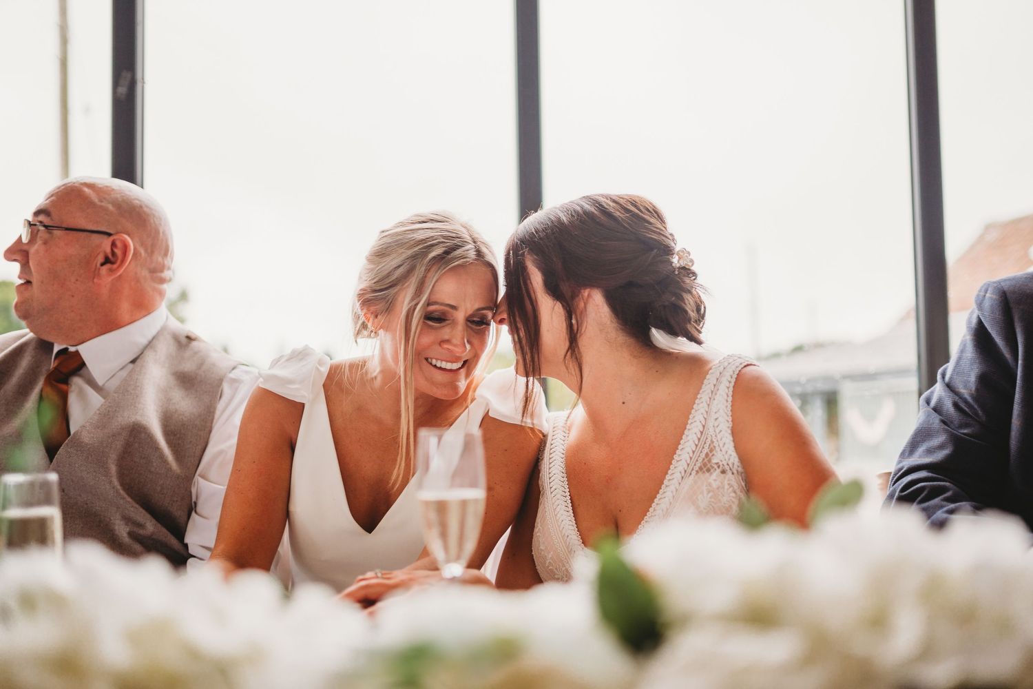 Two brides share a sweet intimate moment during speeches at Mouton Brook Lodge