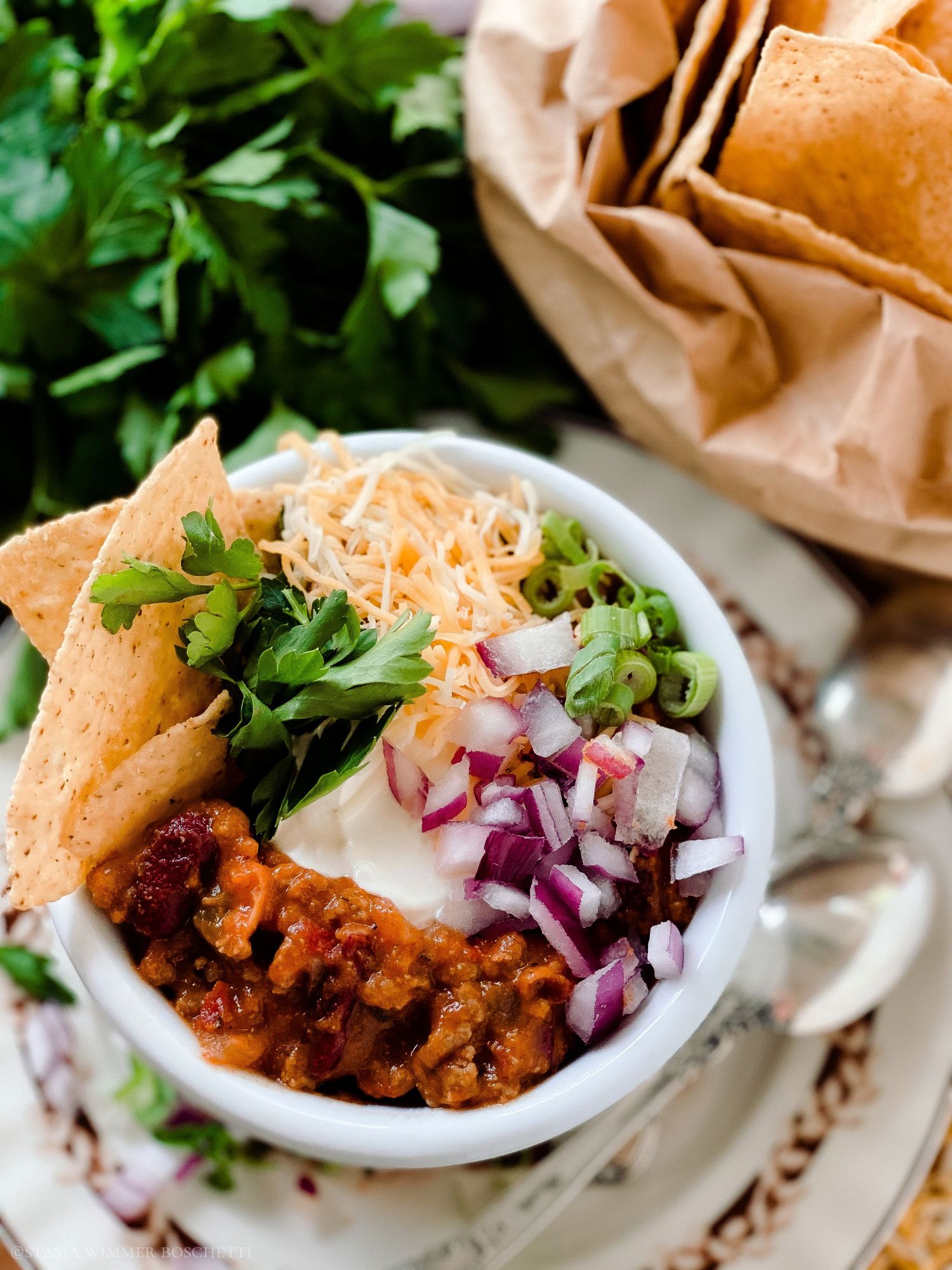 Mexican taco filling with red onions and fresh cilantro served in paper-lined bowls.