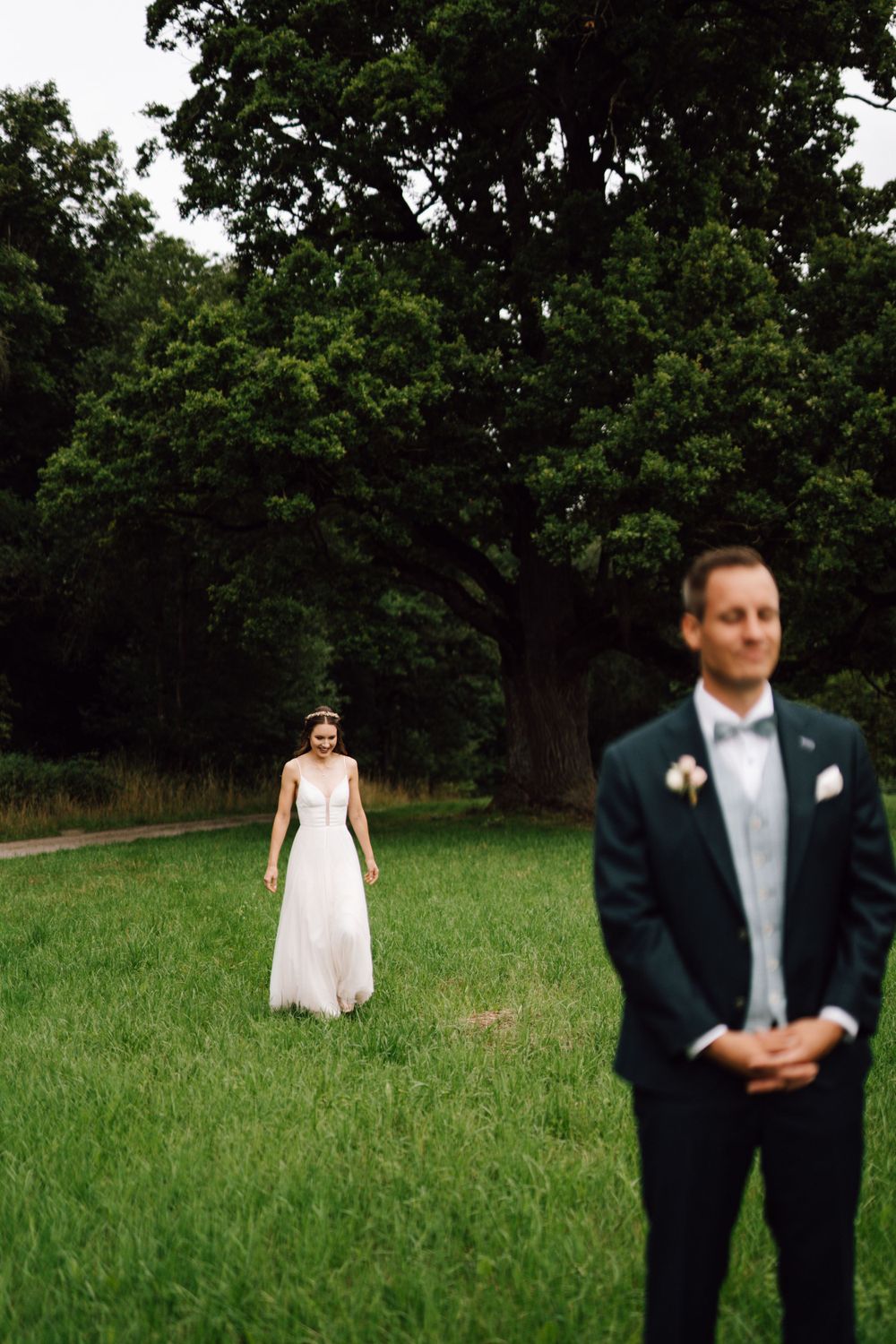 Intimate wedding moment captured in a lush green field with soft natural lighting.