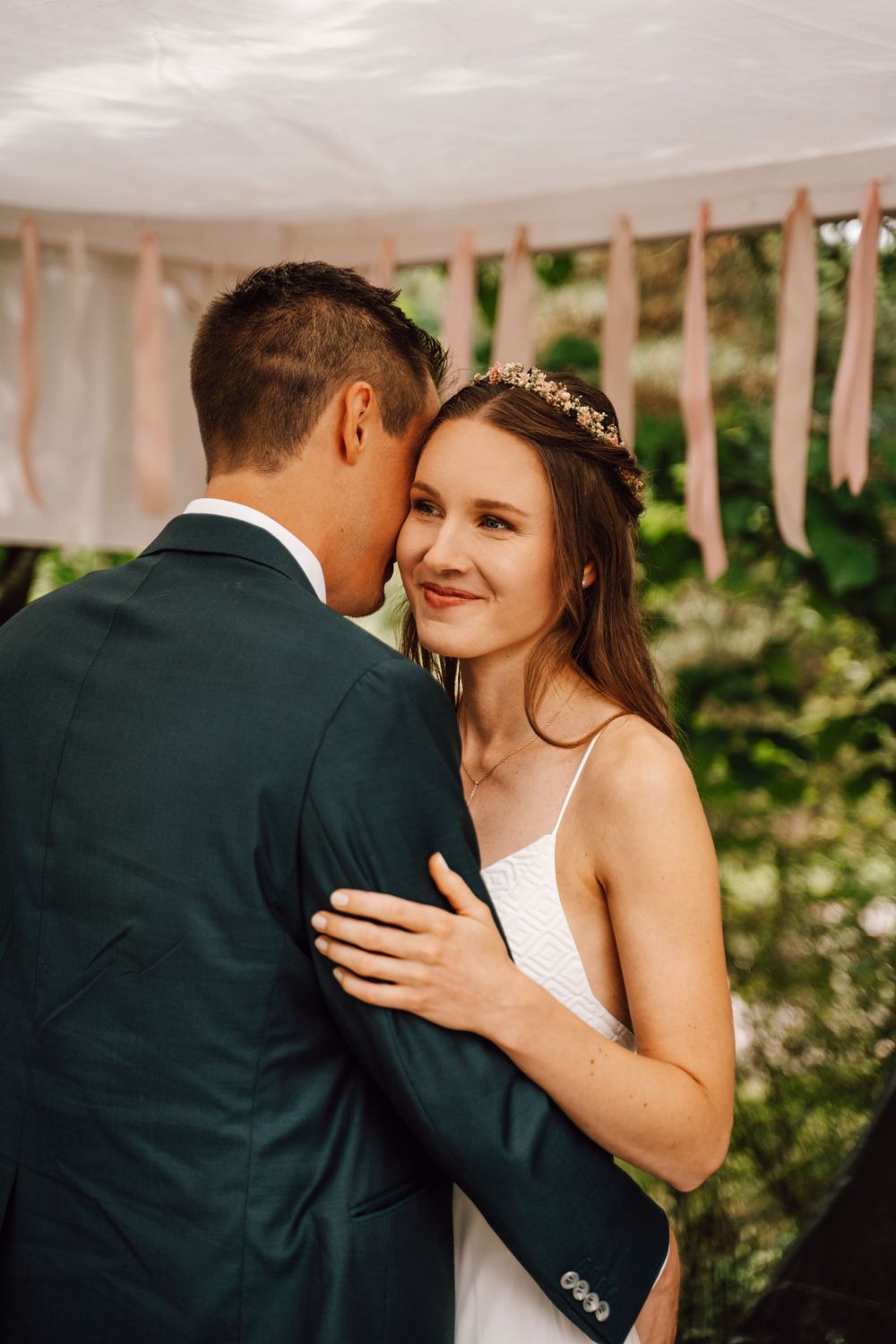 Romantic embrace on a white porch during wedding celebrations.