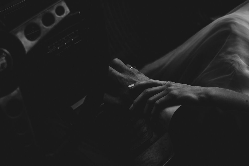 Artistic black and white wedding detail photograph with dramatic shadows.