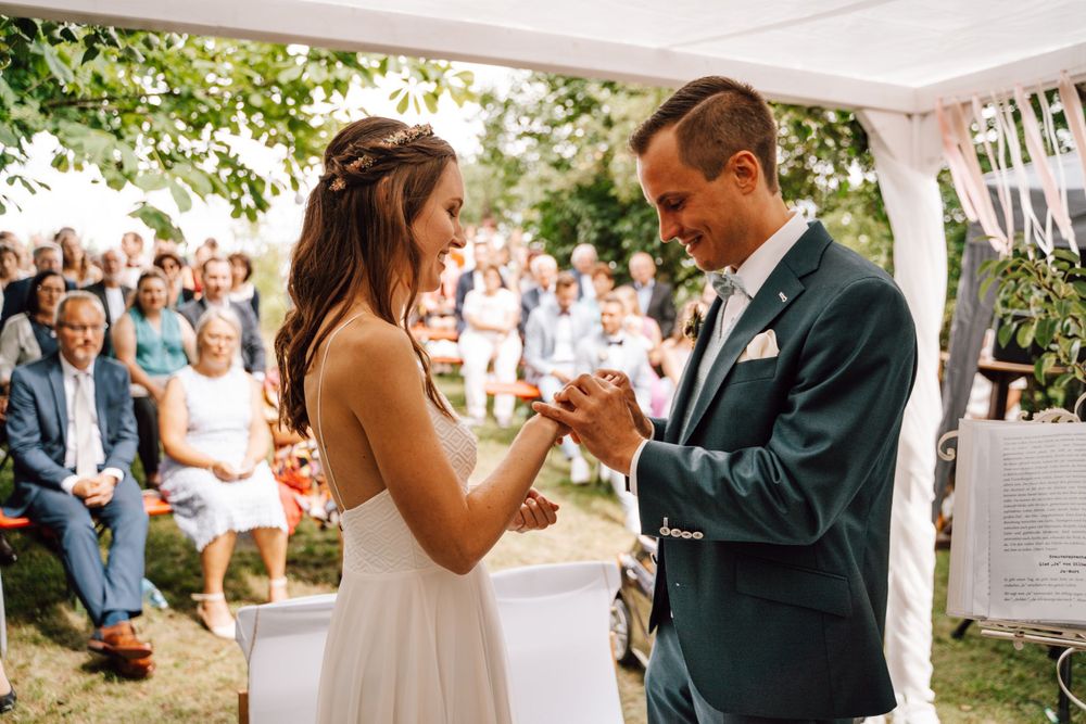 Joyful wedding celebration moments under decorated white tent with guests.