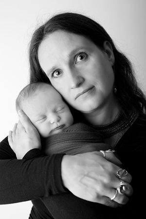 Black and white portrait of a tender moment between mother and sleeping newborn baby.