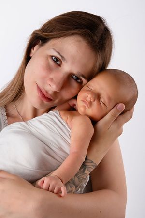 A tender moment between parent and infant in white against light background showing gentle nurturing care.