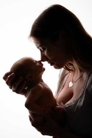 Intimate silhouette portrait of parent and baby sharing a close bonding moment.