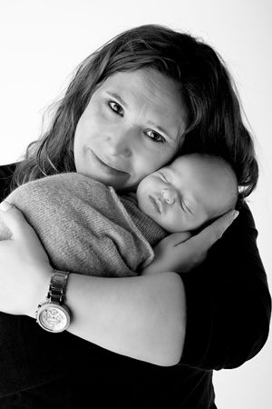 Black and white portrait of parent and sleeping infant in loving embrace.