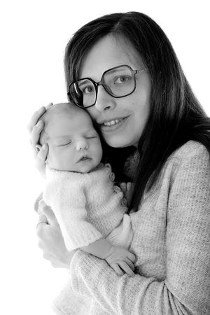 Parent in glasses cuddling peaceful sleeping infant in black and white portrait.