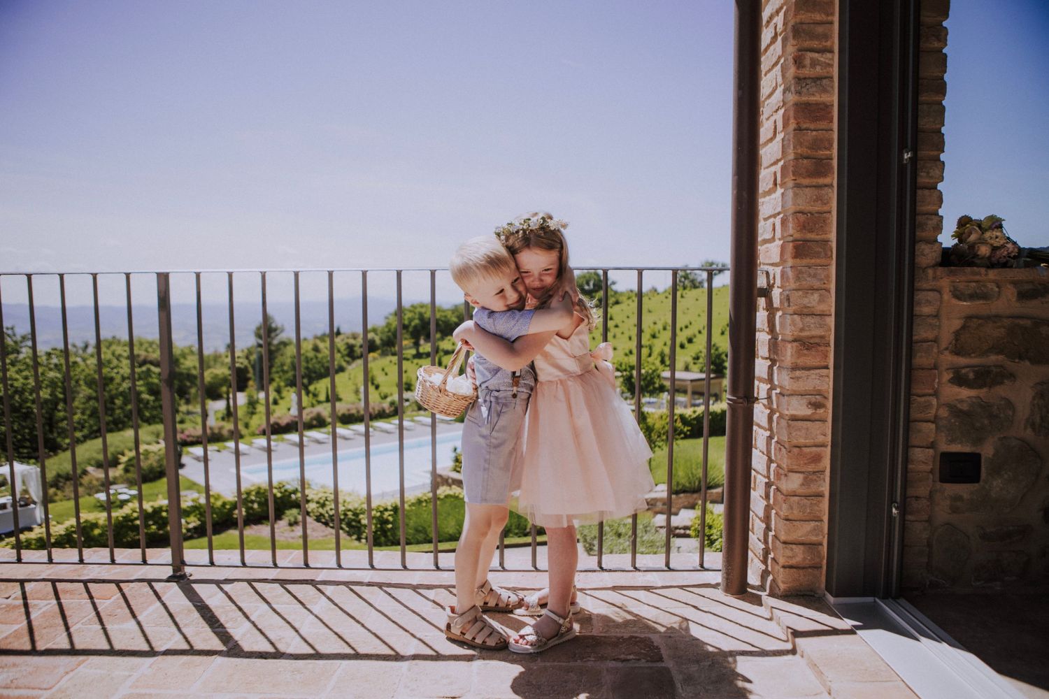 Kids hugging on a balcony at Perugia Vecchia Relais photographed by Gianluca e Arianna Wedding Photographers in Umbria, Italy.