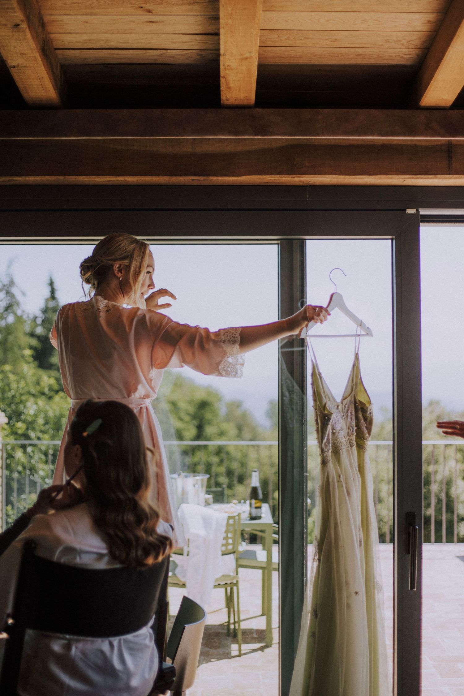 Bridesmaid holding bride's dress at Perugia Vecchia Relais photographed by Gianluca e Arianna Wedding Photographers in Umbria, Italy.