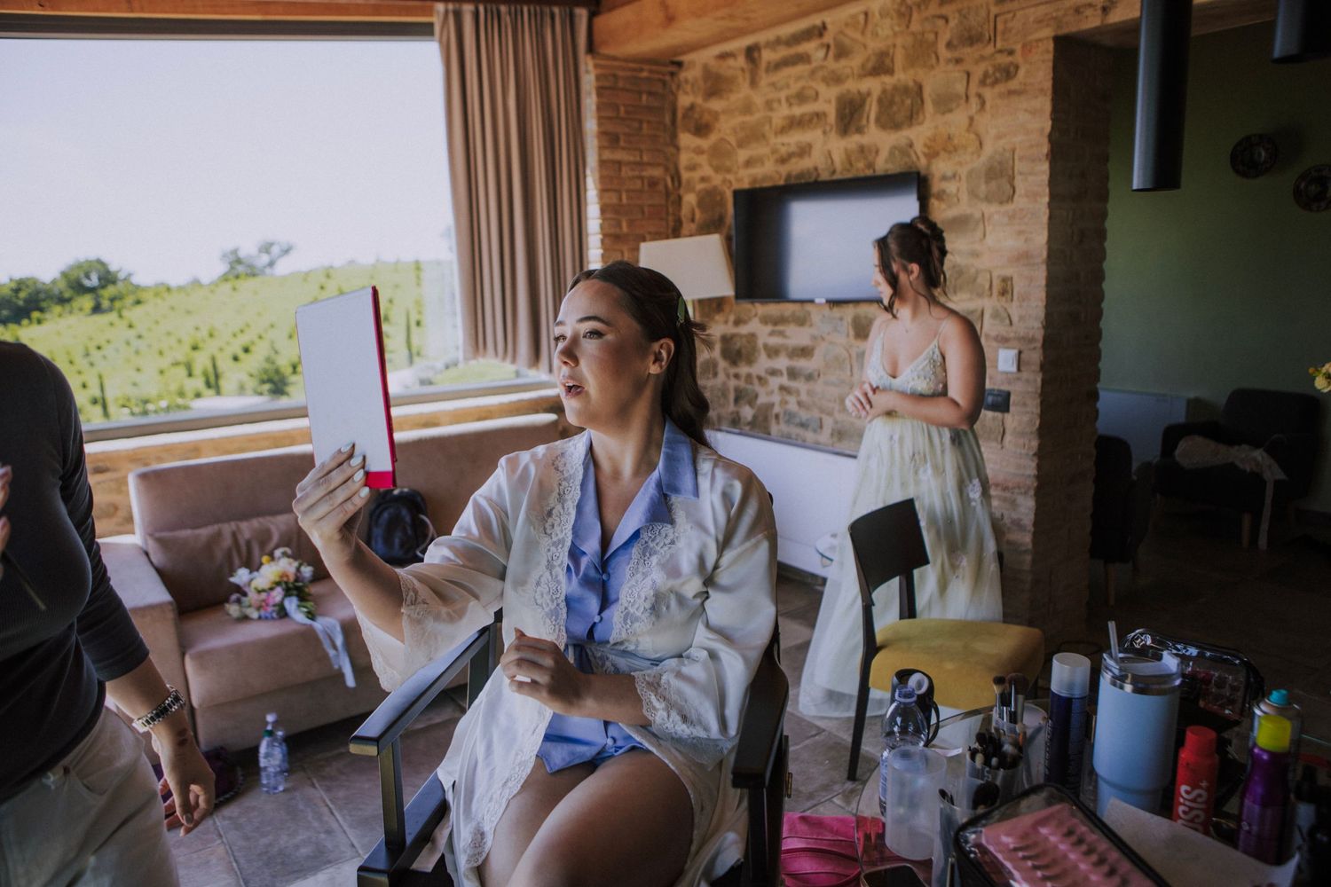 Bride looking herself at the mirror photographed by Gianluca e Arianna Wedding Photographers in Umbria, Italy.