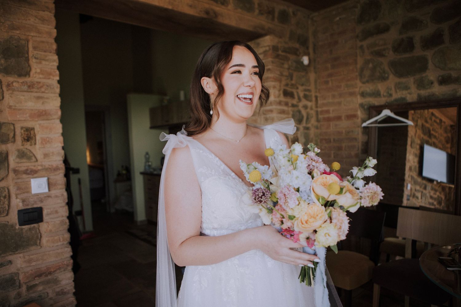 Bride smiling holding her bouquet at Perugia Vecchia Relais photographed by Gianluca e Arianna Wedding Photographers in Umbria.