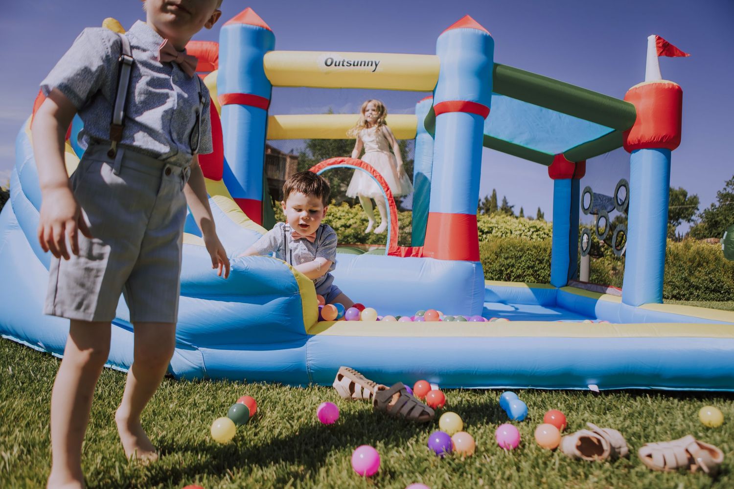 Colorful bounce house with scattered balloons at an outdoor celebration.